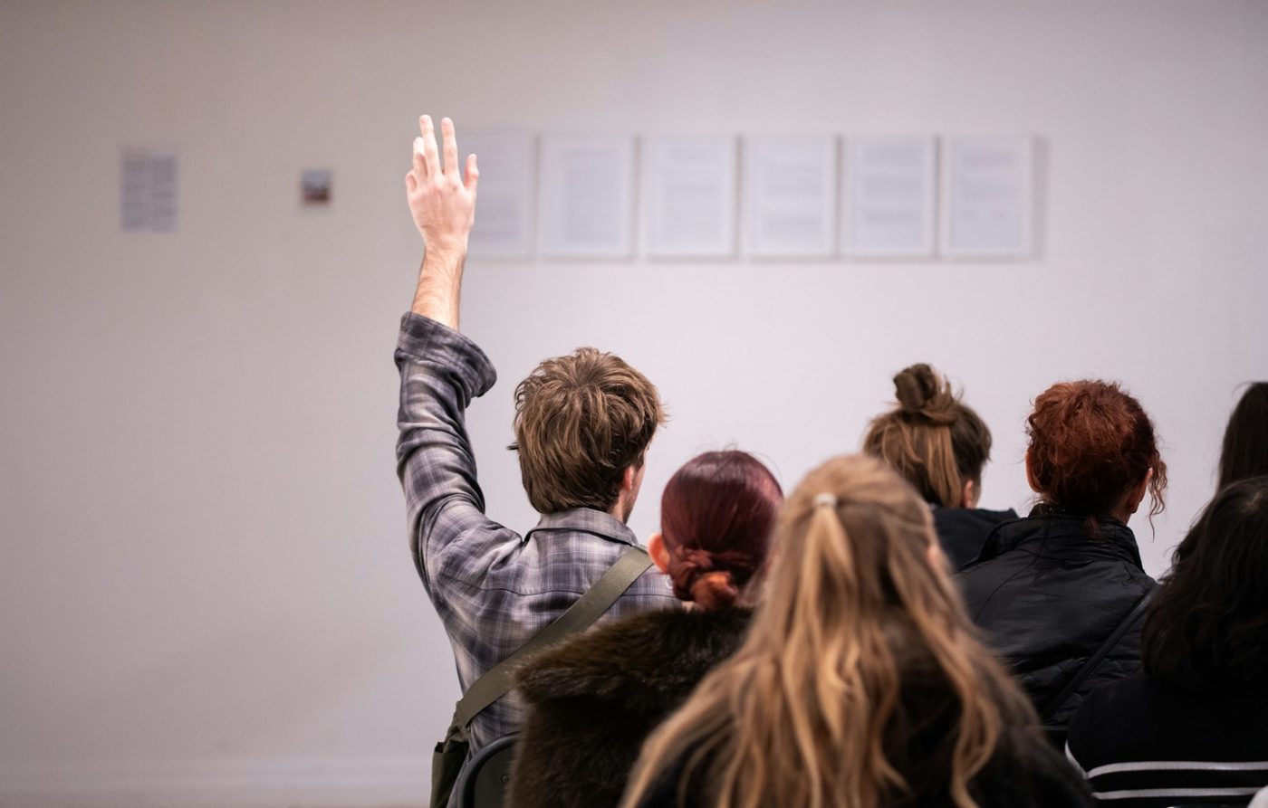 A bidder raising a hand in an auction room