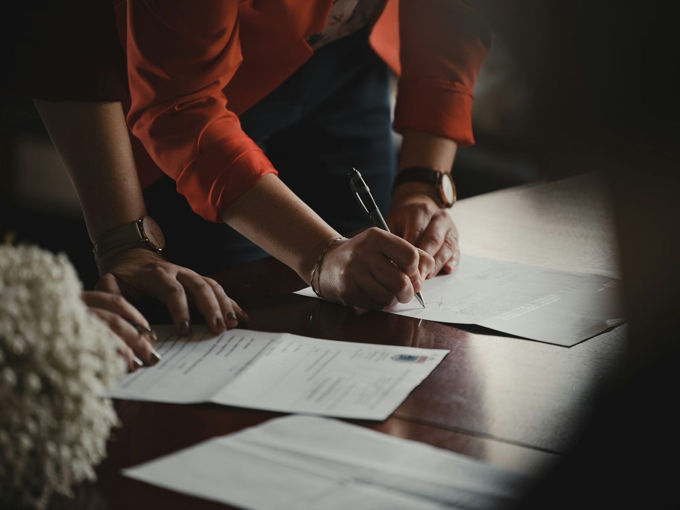 Two people signing a document at a desk